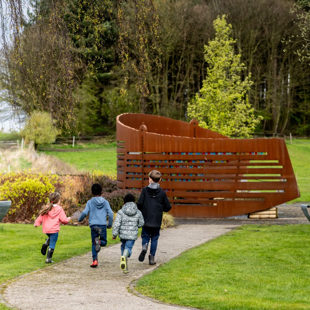 Children running together by the Miners Memorial Garden